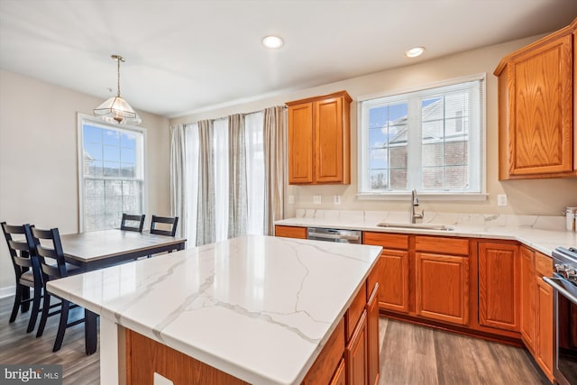 kitchen with decorative light fixtures, a center island, a wealth of natural light, sink, and dark hardwood / wood-style flooring