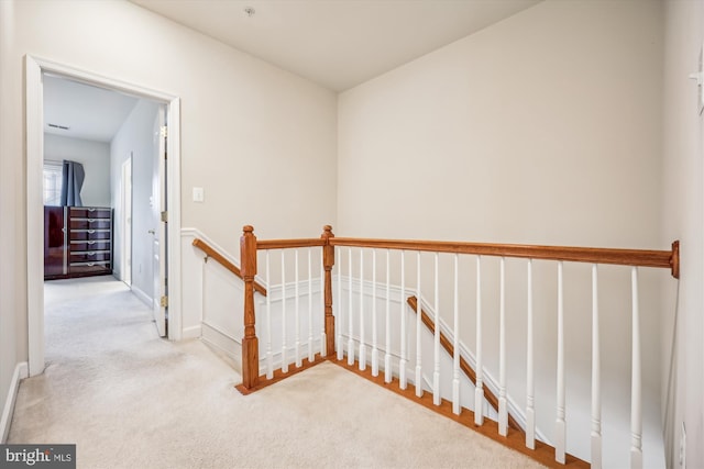 hall with light colored carpet