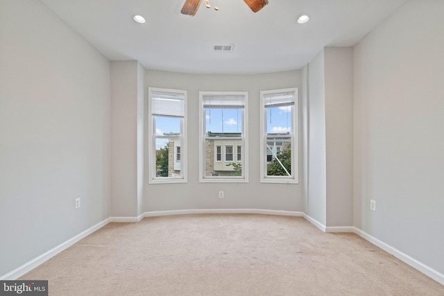 carpeted spare room featuring ceiling fan