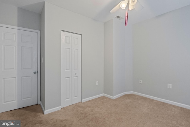 unfurnished bedroom featuring ceiling fan and light carpet