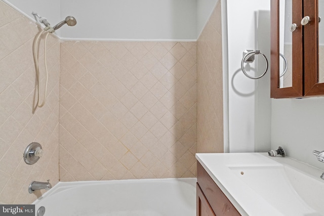 bathroom featuring tiled shower / bath combo and vanity