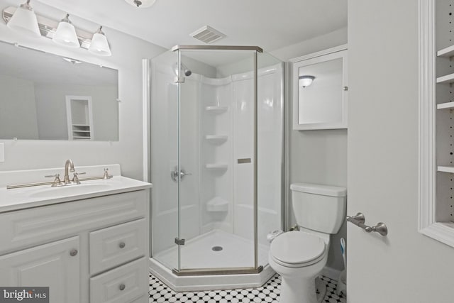 bathroom with tile patterned floors, toilet, a shower with door, and vanity