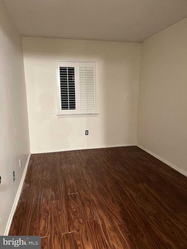 spare room with dark hardwood / wood-style flooring