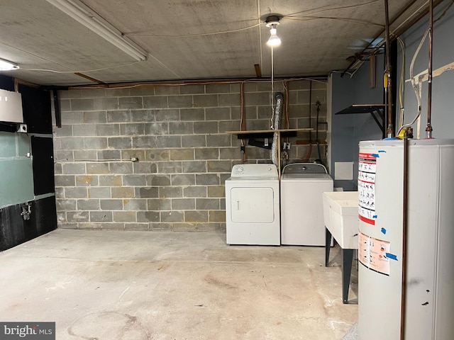 basement with sink, washer and clothes dryer, and water heater