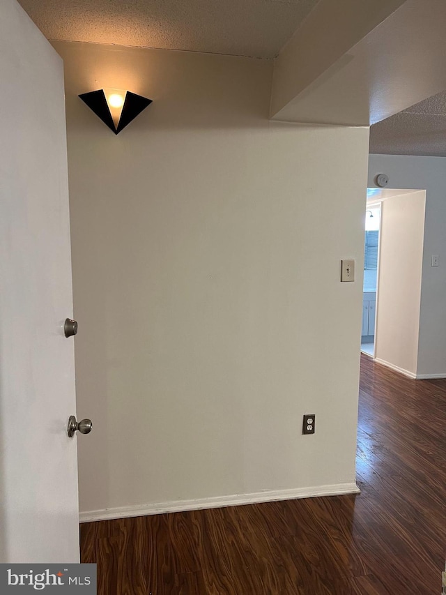 interior space featuring a textured ceiling and dark hardwood / wood-style flooring