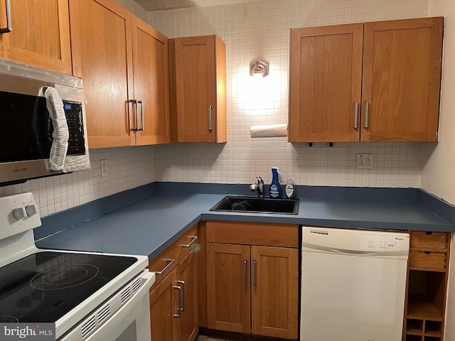 kitchen featuring white appliances, sink, and backsplash