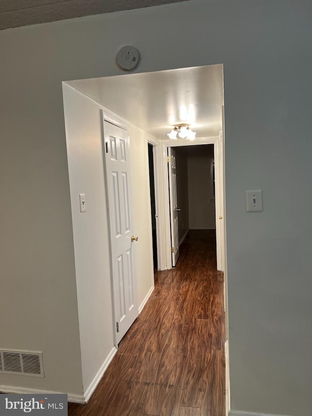 corridor with dark hardwood / wood-style flooring