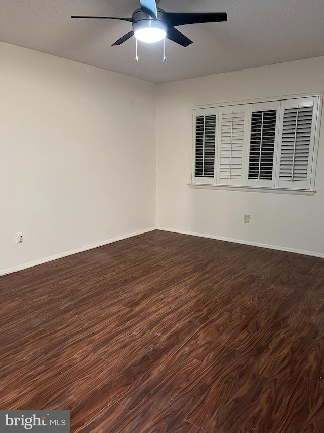 empty room featuring dark wood-type flooring and ceiling fan