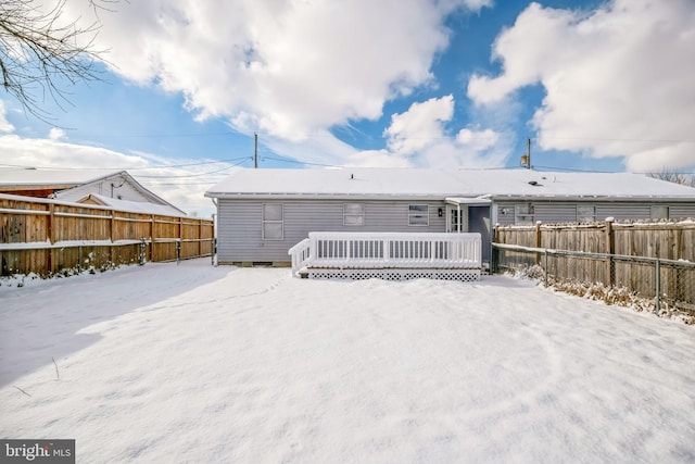 snow covered house featuring a wooden deck