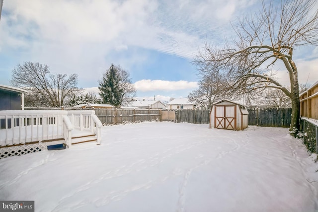 yard layered in snow with a storage shed