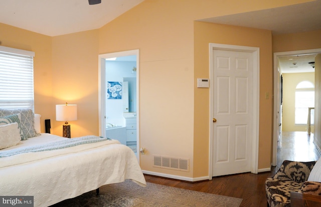 bedroom with ensuite bath, baseboards, visible vents, and wood finished floors