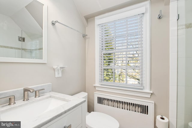 bathroom with toilet, radiator heating unit, an enclosed shower, and vanity