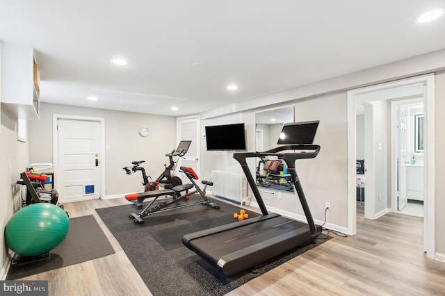 workout room featuring radiator heating unit, baseboards, light wood-style flooring, and recessed lighting