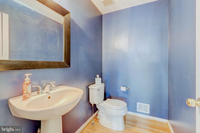 bathroom with hardwood / wood-style flooring, toilet, and sink