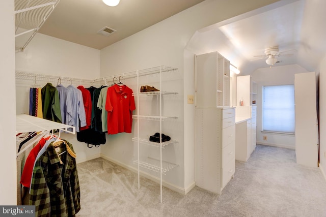 walk in closet featuring lofted ceiling, light carpet, and ceiling fan