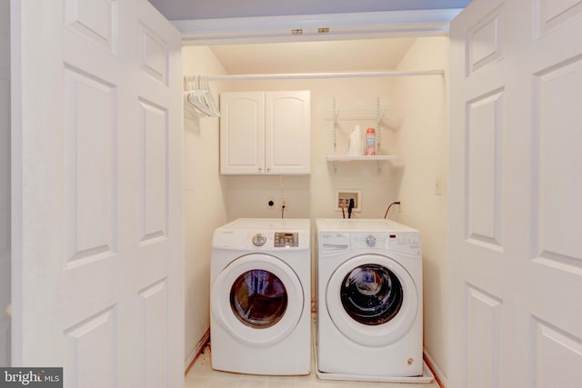 laundry room featuring separate washer and dryer and cabinets