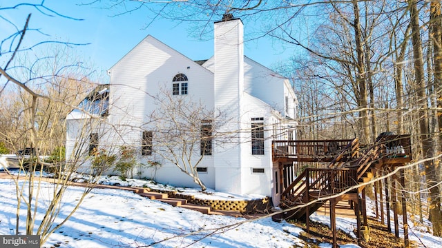 view of snowy exterior featuring a wooden deck