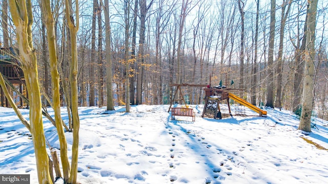 yard layered in snow featuring a playground