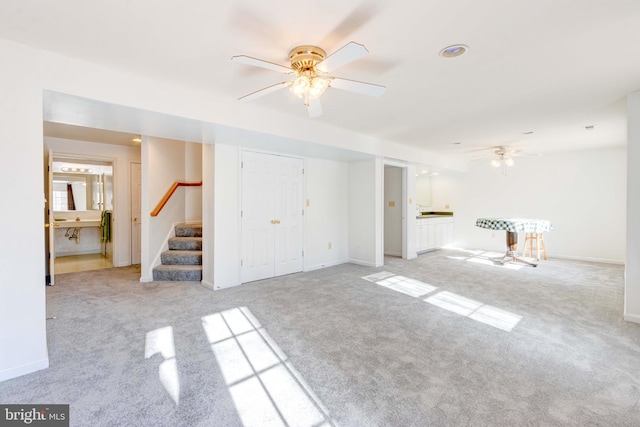 unfurnished living room featuring light carpet and ceiling fan