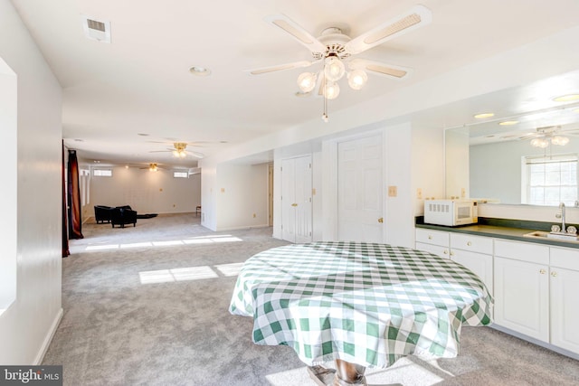 carpeted bedroom featuring sink and ceiling fan