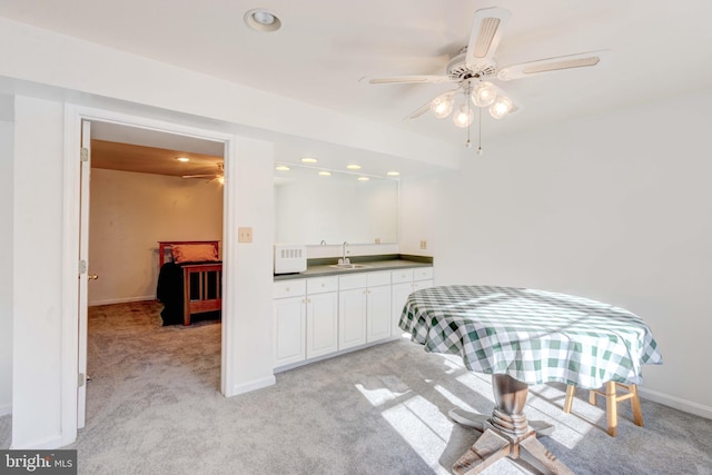 carpeted dining space featuring ceiling fan and sink