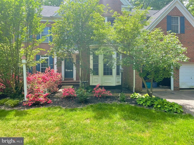 view of front of property featuring a garage and a front lawn