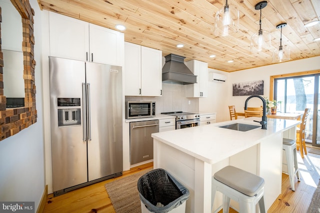 kitchen with wood ceiling, custom exhaust hood, premium appliances, hanging light fixtures, and sink