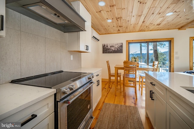 kitchen featuring white cabinetry, stainless steel range with electric stovetop, and custom exhaust hood