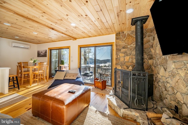 living room featuring a wall mounted AC, a wood stove, wooden ceiling, and light hardwood / wood-style floors