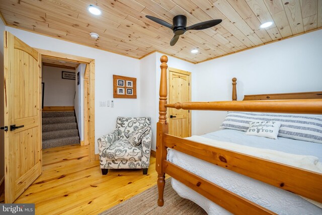 bedroom with ceiling fan, light wood-type flooring, wood ceiling, and ornamental molding