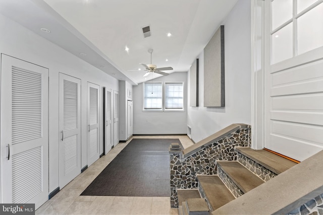 staircase featuring lofted ceiling and ceiling fan