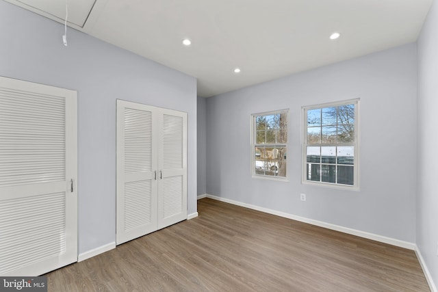 unfurnished bedroom featuring two closets and light hardwood / wood-style flooring