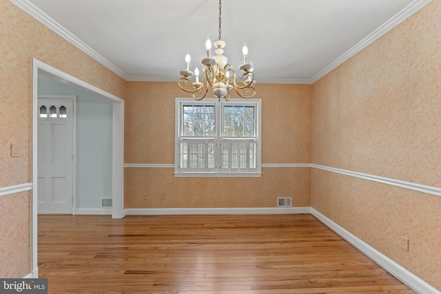 unfurnished dining area featuring ornamental molding, a chandelier, and light hardwood / wood-style flooring