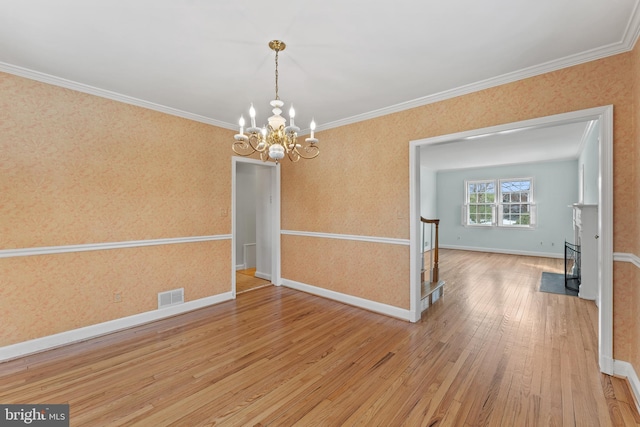 unfurnished dining area featuring an inviting chandelier, crown molding, and wood-type flooring