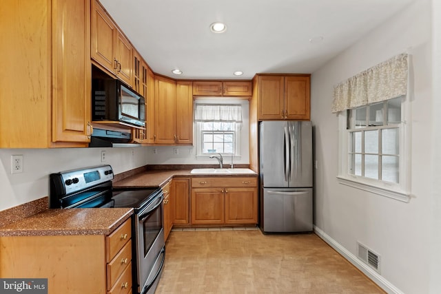 kitchen with stainless steel appliances, extractor fan, and sink