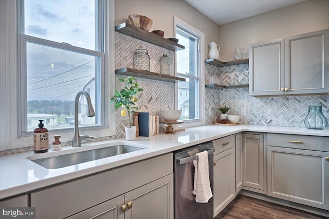 kitchen with gray cabinets, dark hardwood / wood-style floors, dishwasher, sink, and backsplash