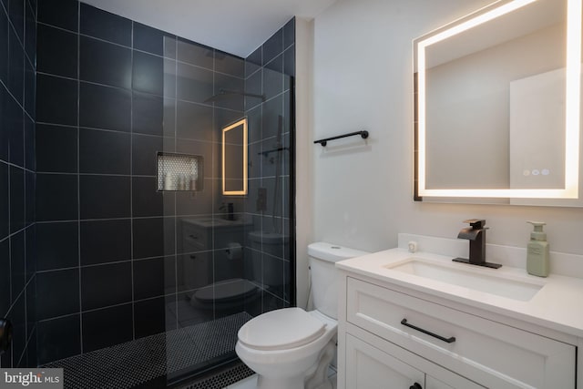 bathroom featuring vanity, toilet, and a tile shower