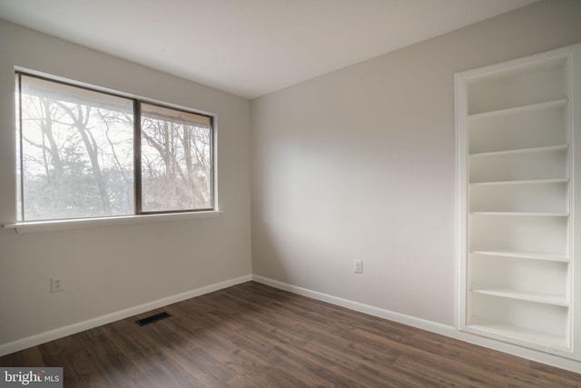 unfurnished room featuring dark wood-type flooring