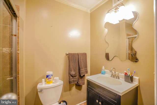 bathroom with toilet, vanity, crown molding, and a shower with shower door