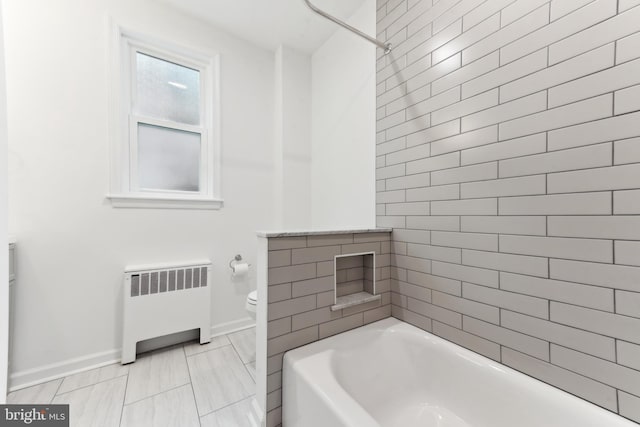 bathroom with toilet, tiled shower / bath combo, and radiator heating unit