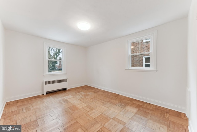 unfurnished room featuring light parquet flooring and radiator heating unit