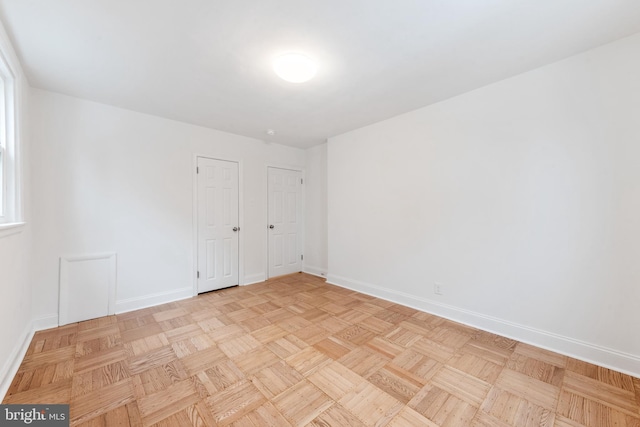 unfurnished room with light parquet flooring