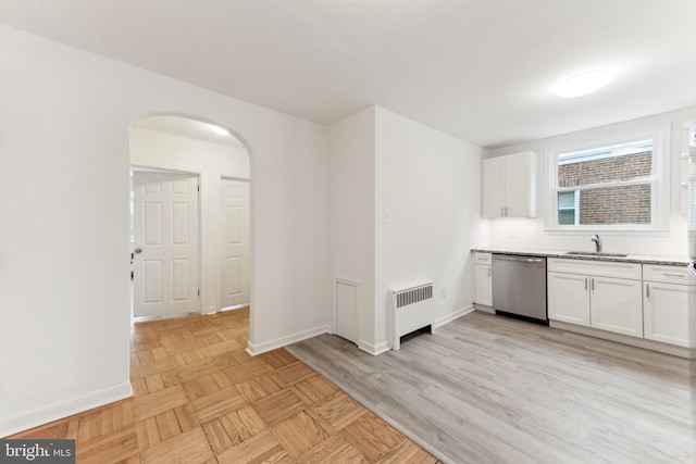 kitchen featuring radiator, dishwasher, white cabinets, and sink