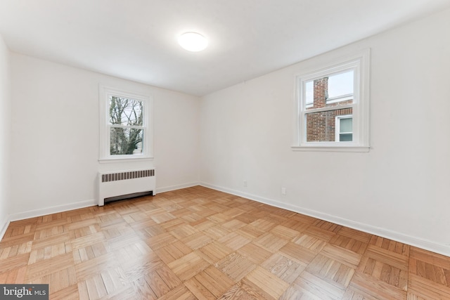 unfurnished room featuring radiator and light parquet floors