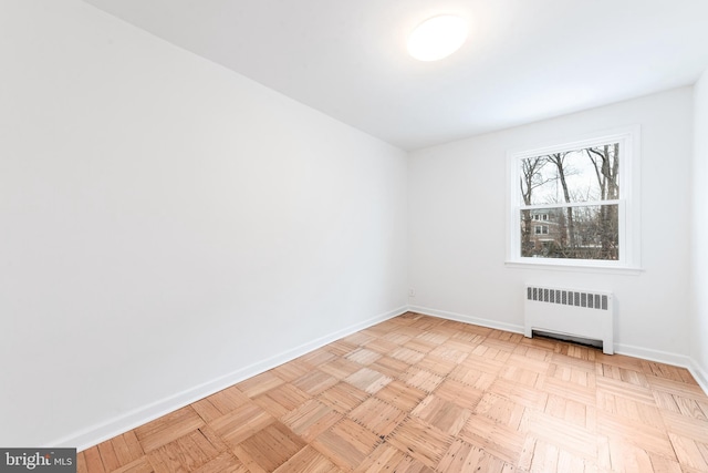 empty room featuring radiator and light parquet floors