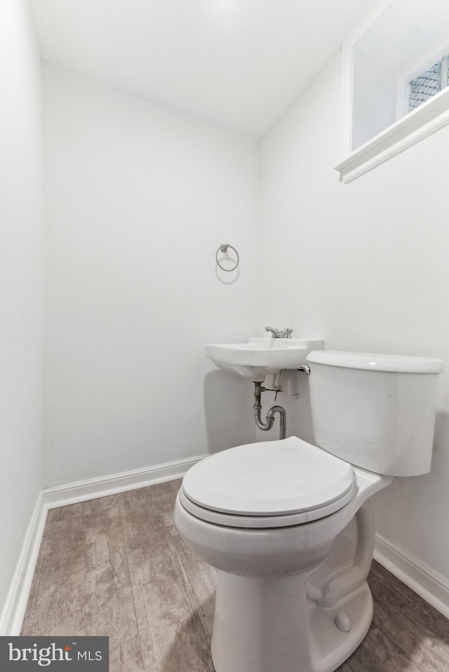 bathroom with toilet and wood-type flooring