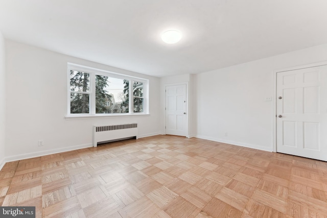 unfurnished room featuring light parquet flooring and radiator