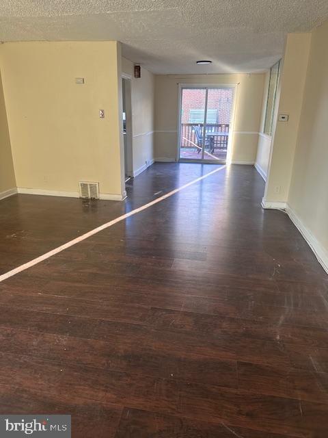 empty room featuring dark hardwood / wood-style flooring and a textured ceiling