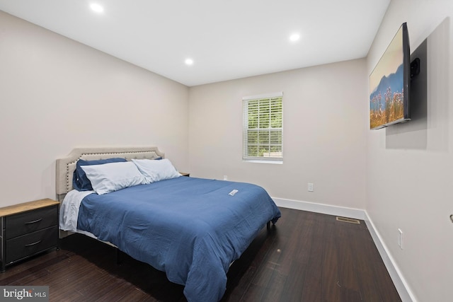 bedroom with dark hardwood / wood-style flooring