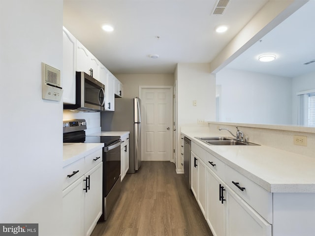 kitchen with dark wood-type flooring, white cabinetry, appliances with stainless steel finishes, and sink